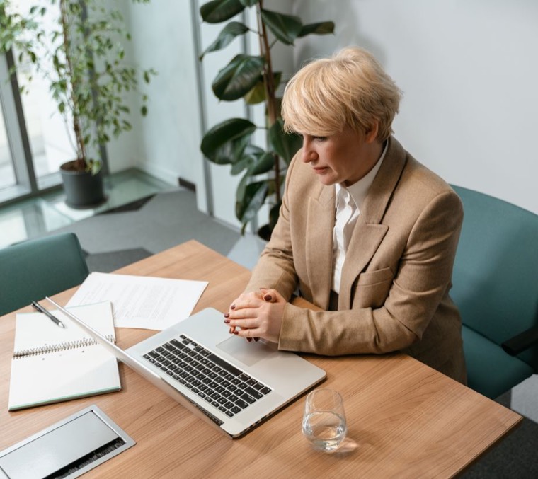 Someone at a desk with a laptop, running work and personal accounts